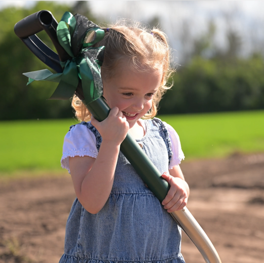 Child holding a ceremonial shovel at Ironhaven